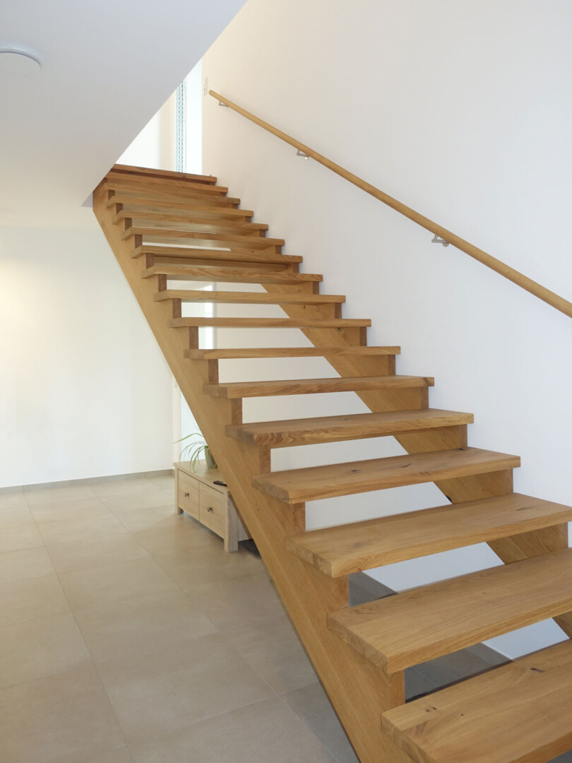 eine moderne Wangentreppe mit Handlauf an der Wand