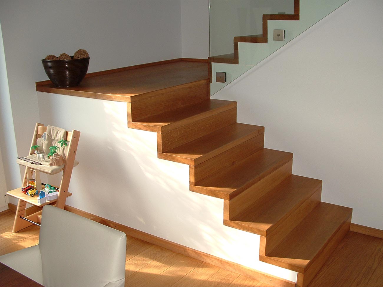 Betontreppe in einem Wohnzimmer, kinderfreundlich mit seitlich angebrachten Glasscheibengeländer