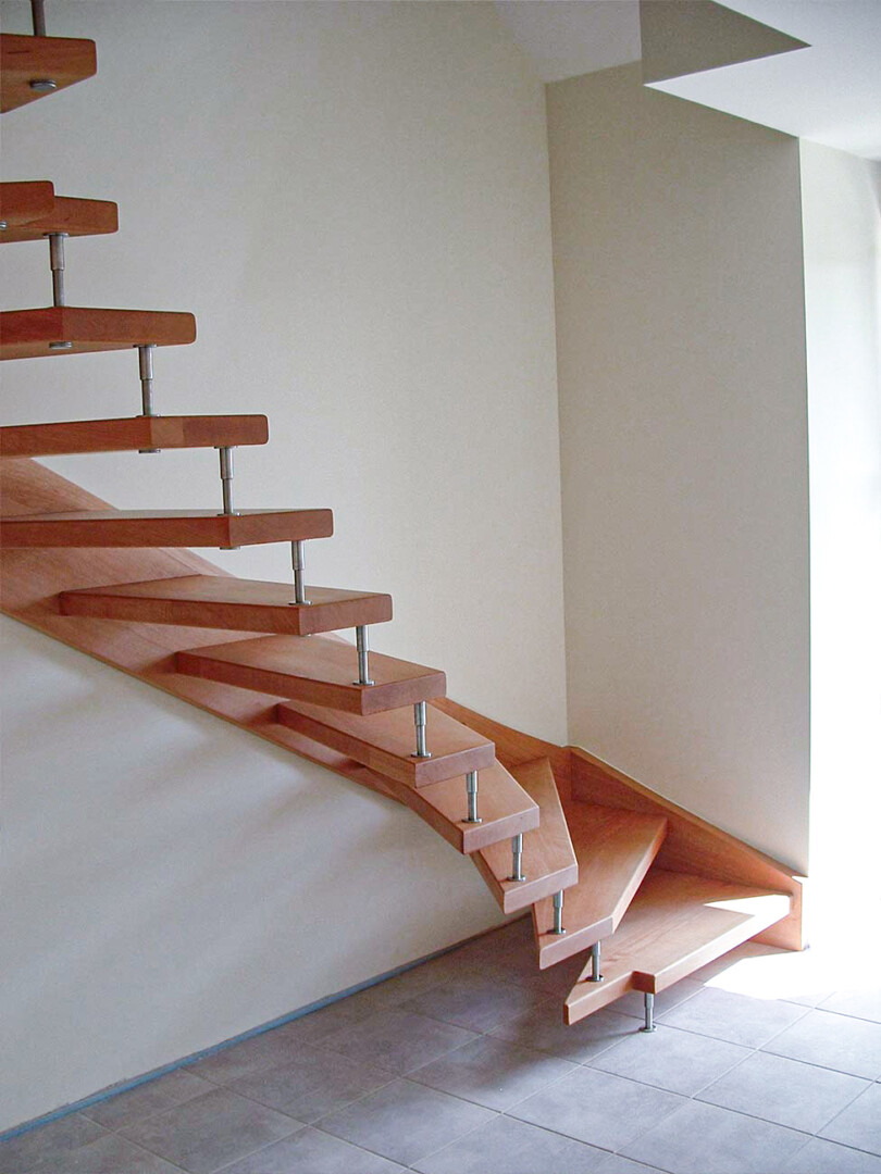Thummtreppe aus hellem Holz, die sich um eine kleine Ecke windet