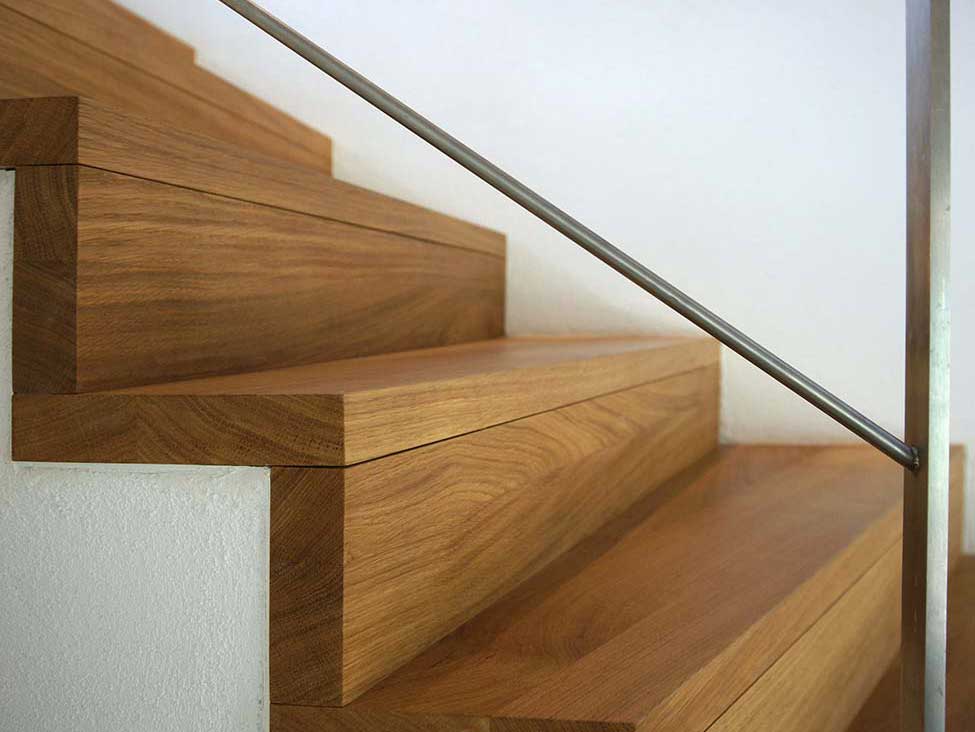 Nahaufnahme einer Betontreppe und den Holzstufen sowie dem geschweißten Geländer