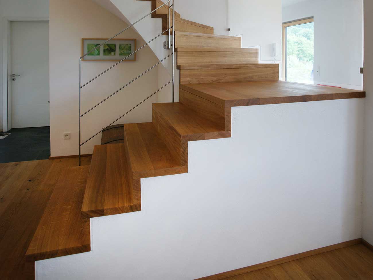 Betonsockel mit aufgetragenen Holzstufen, Betontreppe mit Metallgeländer