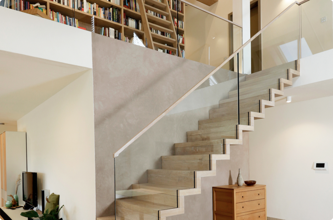 Eine Faltwerktreppe aus Holz mit Geländerscheiben aus Glas