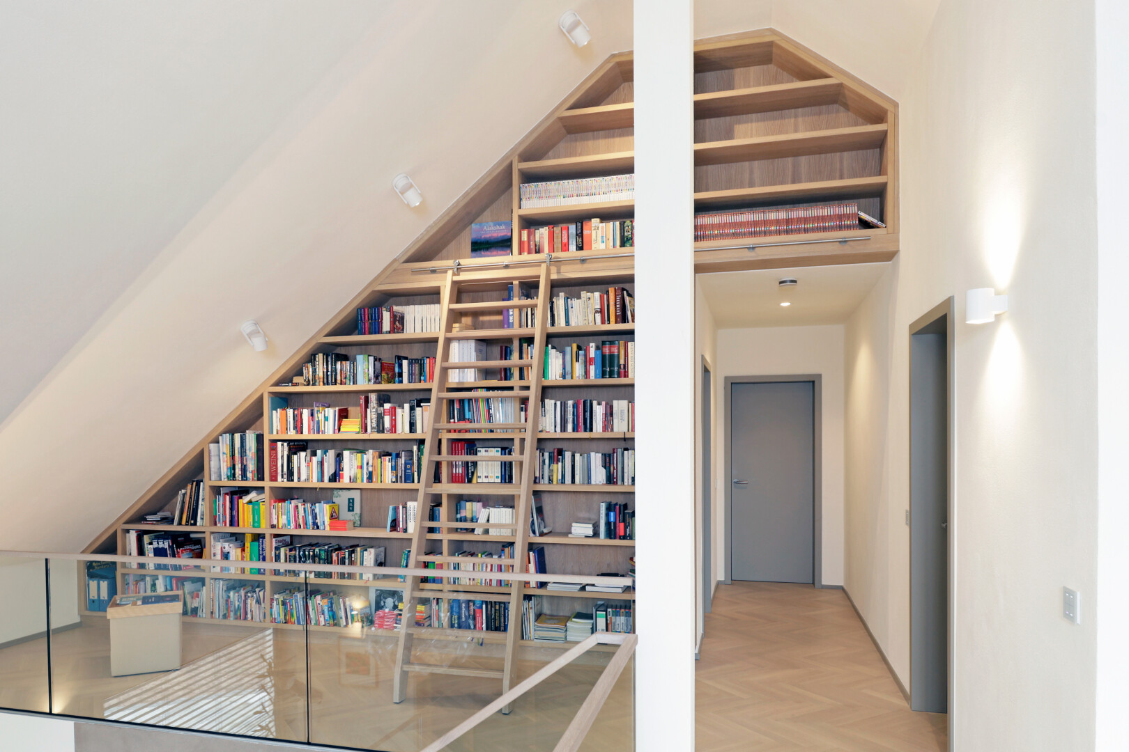 Eine grossflächige Schrankwand als Bücherregal in der Schräge eines Dachgeschosses